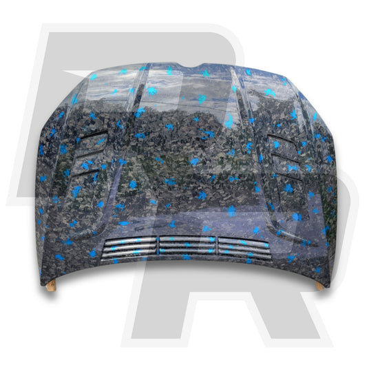 Car hood with a forged carbon fiber design on a white background